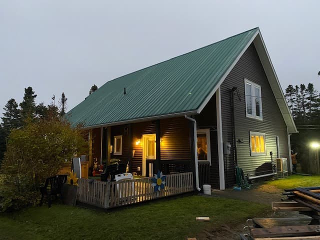 Newfoundland residential cabin with green metal roof in evening fog